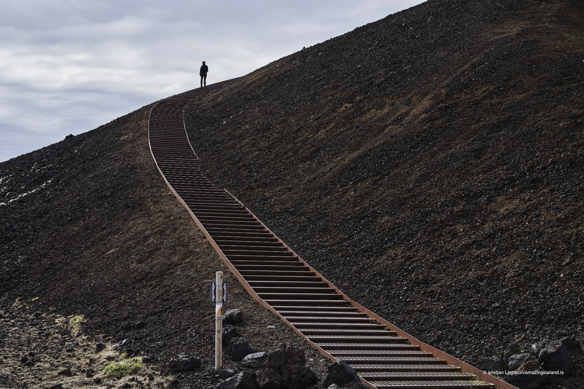 Man walking down the 385 steps of awarded stairs at Saxhóll volcanic crater in Snæfellsnes